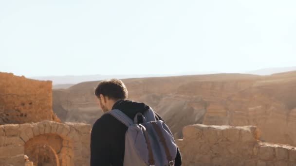 Mužské turistické fotky úžasné horské scenérie. Mladý muž s batohem vyfotí. Svoboda. Masada Izrael 4k. — Stock video