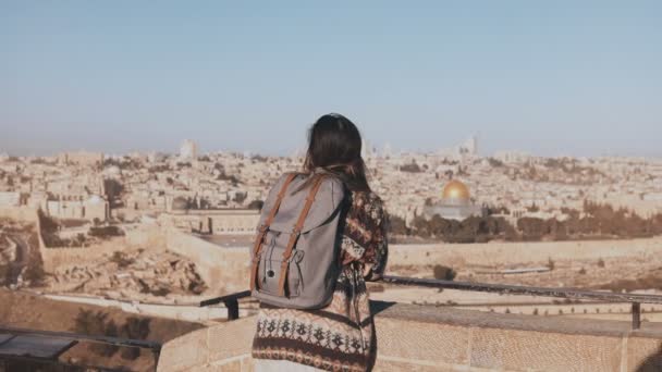 Jong meisje met rugzak geniet Jerusalem panorama. Doordachte Europese toeristische kijkt naar de oude binnenstad in Israël. 4k. — Stockvideo