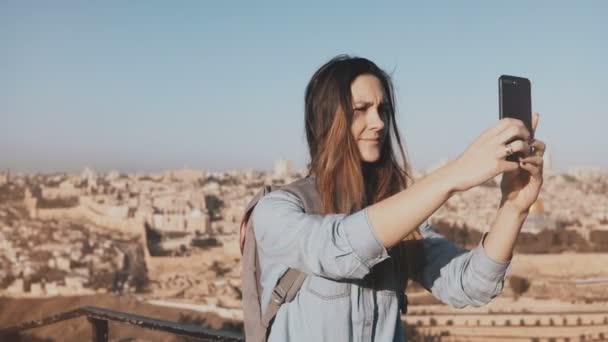 Mooi meisje neemt selfie in de oude stad Jeruzalem. Leuke lokale meisje glimlacht gelukkig, nemen van foto's. Oude Israël panorama 4k. — Stockvideo