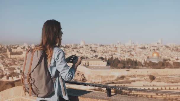 Θηλυκό τουριστών παίρνει φωτογραφίες της παλιάς πόλης της Ιερουσαλήμ. Ταξιδιώτης αρκετά καυκάσιος γυναίκα, που χαμογελά με σακίδιο. Ισραήλ. 4k. — Αρχείο Βίντεο