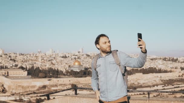 Счастливчик делает селфи в старом городе Иерусалиме. Бородатый местный мужчина улыбается счастливо, фотографирует. Искусственная панорама Израиля 4K — стоковое видео