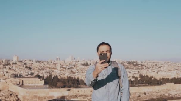 Turisztikai ember beszél videóinak telefon hív. Jerusalem, Izrael. Európai férfi ember boldog és izgatott Társalgások. Lassú mozgás. — Stock videók