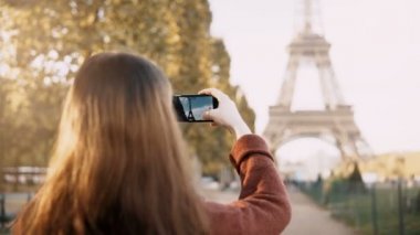 Genç genç Eyfel Kulesi Paris, Fransa'da fotoğrafını çekmek için smartphone kullanarak kadın arkadan görünüm.