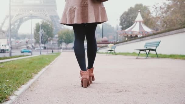 Vista de cerca del pie femenino. Joven mujer elegante caminando cerca de la torre Eiffel en París, Francia temprano en la mañana . — Vídeos de Stock