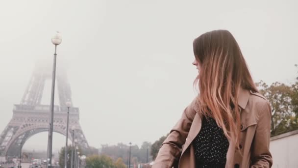 Ung snygg kvinna står ensam och tittar på Eiffeltornet i Paris tidigt i Dimmig morgon. Slow motion. — Stockvideo