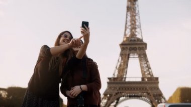 İki kadın alarak fotoğraf smartphone Eiffel yakınındaki seyahat eden güzel güneşli bir günde Paris, Fransa'da kule.