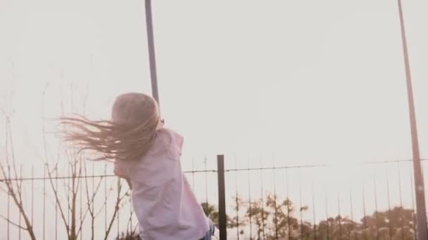 A mãe empurra a filha em um balanço de corda de playground. Movimento lento. Menina feliz monta um fio longo zipline. Ligação familiar . — Vídeo de Stock