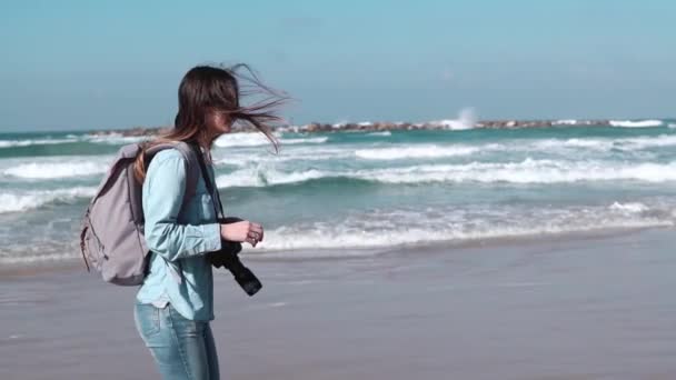 Kvinnlig turist promenader längs sommaren seashore. Frihet-konceptet. Vinden blåser i håret. Havets vågor. Slow motion sidovy. — Stockvideo