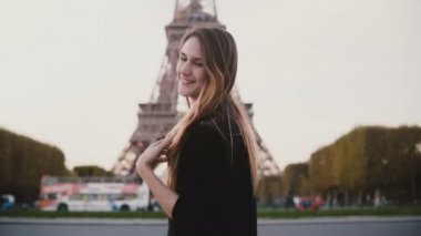 Paris, Fransa'da Eyfel Kulesinin yakınında duran mutlu güzel kadın. Kameraya gülümseyen ve darbe gönderme kızını öp.