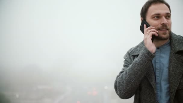 Fiatal férfi beszélgetett a mobiltelefon valaki reggel. Férfi háttér pályát torony, Paris, Franciaország. — Stock videók