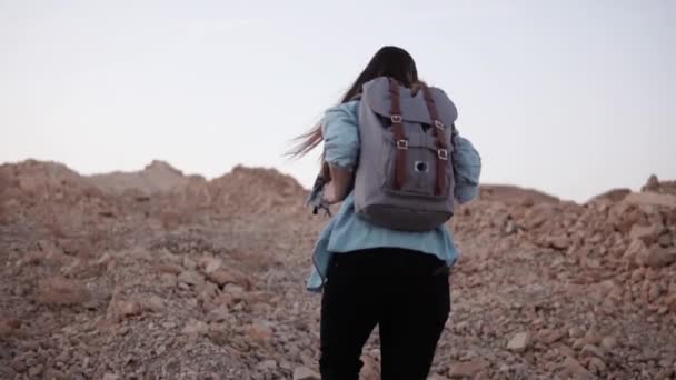 Kadın dik kayalık bir tepe üzerinde zamları. Ağır çekim. Turist kız dağ büyük taşlarla tırmanıyor. Zor yol tepeye. — Stok video