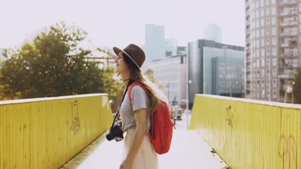 모자에 흥분된 소녀, 긴 머리는 다리에 산책. 유럽 여성 여행자 행복, 차례 노란색 벽 사이 라운드. 4 k. — 비디오