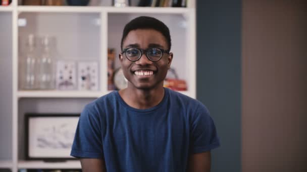 Feliz hombre afroamericano mira a la cámara. Guapo chico joven negro en gafas elegantes sonríe alegremente. Expresión 4K — Vídeos de Stock