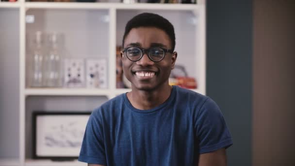 Retrato de estudiante universitario afroamericano. El joven negro feliz con gafas sonríe, y luego se vuelve serio. Emociones 4K — Vídeos de Stock