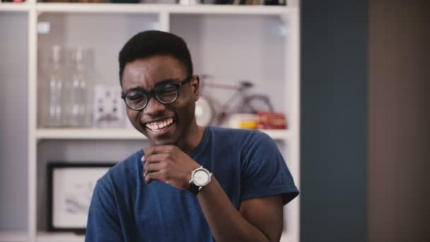 Genç Afrikalı-Amerikalı adam farklı duygu gösterir. Gözlüklü yakışıklı siyah adam gülüyor, o zaman ciddi ve tekrar. 4k. — Stok video
