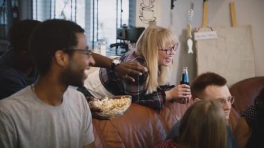 Arkadaşlar birlikte, izle komik film spor izlerken, tartışırken, sevinçle sohbet Tv. çok etnik grup üzerinde oturmak.