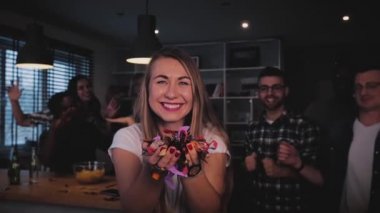 Güzel Avrupa kız konfeti üfleme. Mutlu heyecanlı Bayan darbeler glitter çok etnik parti üzerinde. Kutlama dans.