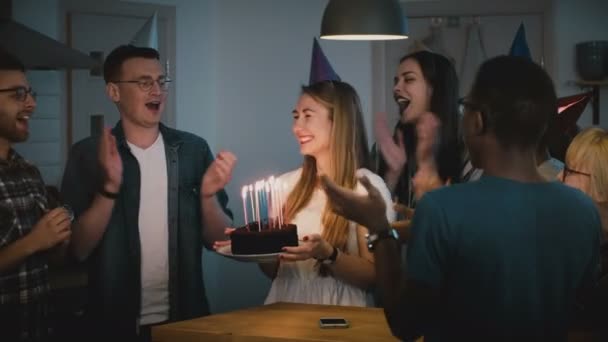幸せな白人の女の子は、希望の誕生日ケーキを作る。多様なグループは一緒に友人の祝日を祝います。魔法の瞬間。4 k — ストック動画