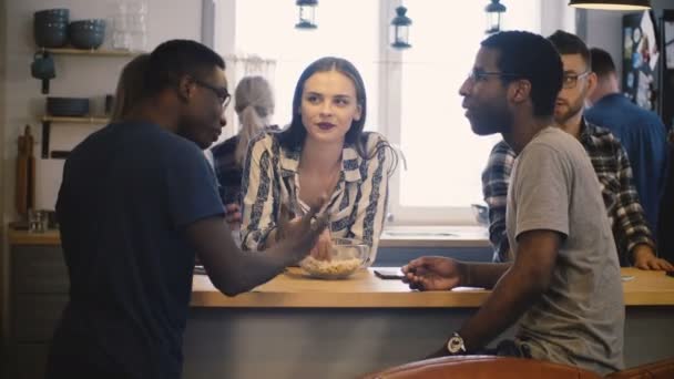 Diverso grupo de amigos en una fiesta de la casa. Conversación casual en la mesa de la cocina. Jóvenes multiétnicos. 4K . — Vídeos de Stock