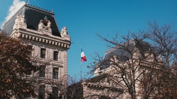 パリ、フランスの警察の県。フランスの国旗は、晴れた日の青い空を飛んでします。ヨーロッパの歴史的建造物。4 k — ストック動画