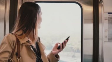 İş kadını ile smartphone metro arabada. Genç ve güzel kadın banliyö Messenger app kullanma online. Kablosuz 5g. 4k
