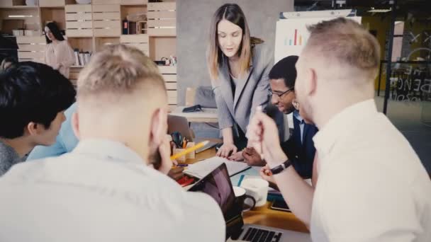 Une femme chef d'équipe explique les nouvelles responsabilités aux employés. Heureux collègues multiethniques réunis dans un bureau moderne 4K . — Video