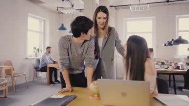 Kamera kadın patron işçi teşvik izler. Kadın yönetici modern ofis alanı 4 k karışık yarış meslektaşları ziyaret.