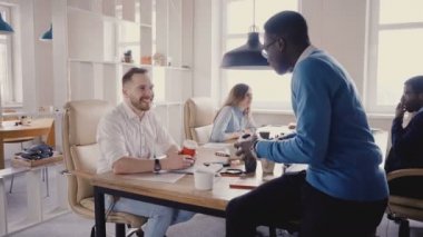 Ofiste konuşmak mutlu çok ırklı meslektaşları. Genç karışık yarış iş ortakları geçici ofis atmosferi 4 k tadını çıkarın..