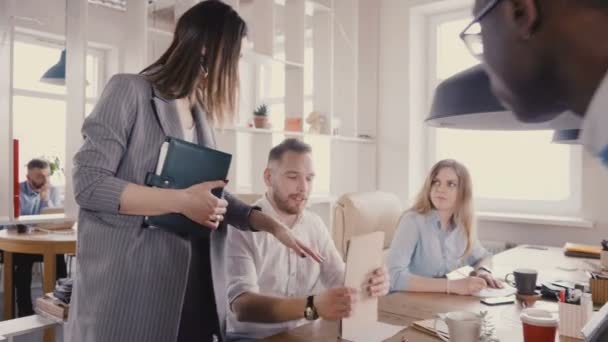 Camera follows female CEO motivating workers. Woman boss chats with colleagues, gives them directions in loft office 4K. — Stock Video