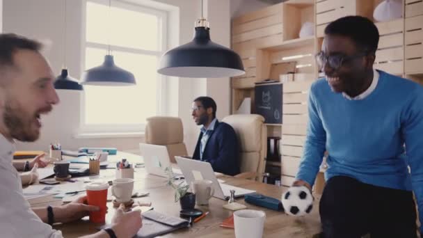 Афроамериканский рабочий разговаривает с боссом компании. Счастливые коллеги по этнической принадлежности работают в модных офисных помещениях на чердаке 4K . — стоковое видео
