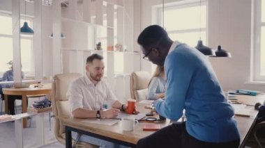 Modern ofiste konuşan mutlu çok ırklı arkadaşlar. Gülümseyerek, 4 k coworking trendy chat yapan genç çeşitli iş arkadaşları.