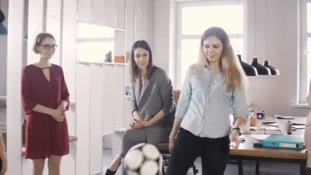 Случайные офисные работники играют с мячом во время перерыва. Счастливые стартаперы празднуют финансовый успех в коворкинге 4К . — стоковое видео