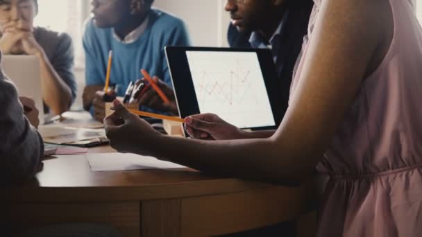 Female employee holds pencil at office meeting. Young multiracial happy millennials work in modern office close-up 4K. — Stock Video