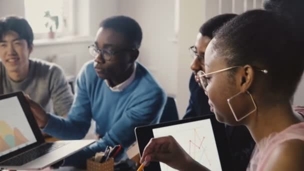 Афроамериканский бизнесмен на встрече в офисе. Молодые бизнесмены обсуждают финансовые диаграммы на ноутбуке 4K . — стоковое видео