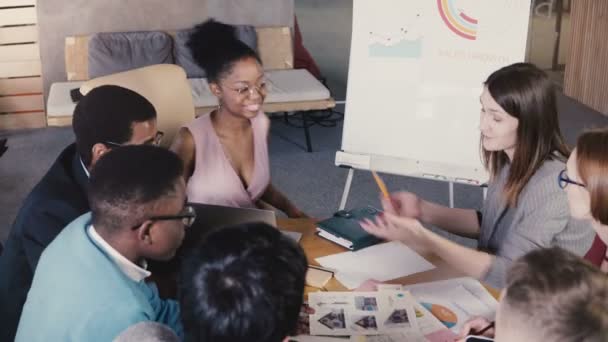 Travail d'équipe dans un loft branché espace de coworking d'entreprise. Jeunes employés créatifs multiethniques heureux brainstorming ensemble 4K .