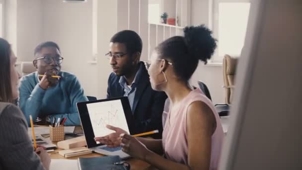 Il capo afroamericano che conduce una riunione. I giovani millennials di razza mista analizzano le tendenze del mercato sul grafico 4K . — Video Stock