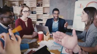 Office toplantıda konuşan çok ırklı iş arkadaşları. Mutlu genç iş adamları ortaklık anlaşması 4 k geliştirme.