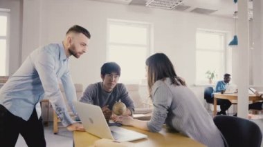 Kamera geliyor ve meslektaşları konuşmak Kafkas Yöneticisi izler. Modern ofis 4k mutlu çok ırklı çalışanlar.