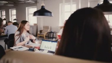 Genç kadın işçiye takım toplantısında konuşuyor. Mutlu karışık etnik köken yaratıcı Bölümü çalışanları projeyi 4 k tartışmak.