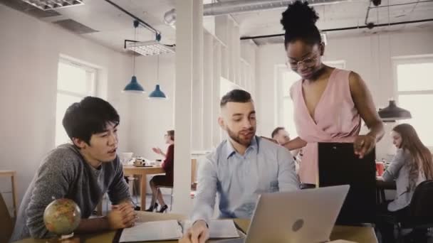 Camera volgt gelukkig zwarte vrouwelijke leider Voer office, praten met collega's. Multi-etnisch collega's in moderne coworking 4k — Stockvideo