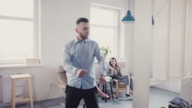 Komik deli modern ışık Office 4 k heyecanlı çok etnik gruptan oluşan meslektaşları ile işadamı kutluyor zafer dansı.