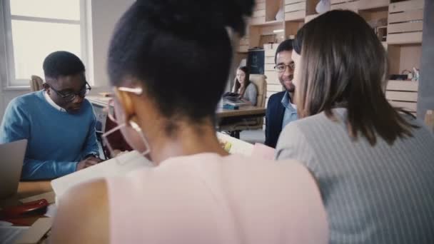 Menschen mit gemischter Rasse lesen Geschäftsunterlagen. Zufriedene junge Mitarbeiter lesen Vertragsvereinbarungen bei Büromitarbeiterversammlung. — Stockvideo