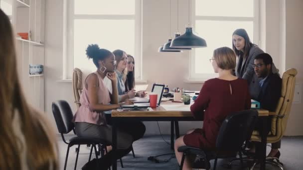 Happy female business coach gives guides to employees. Multiethnic teamwork by the table at office board meeting 4K. — Stock Video