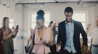 Afrikalı-Amerikalı kadın ve erkek çalışanların komik yapıyor çok ırklı meslektaşları 4 k ile ofis partisinde etnik dans hareketleri