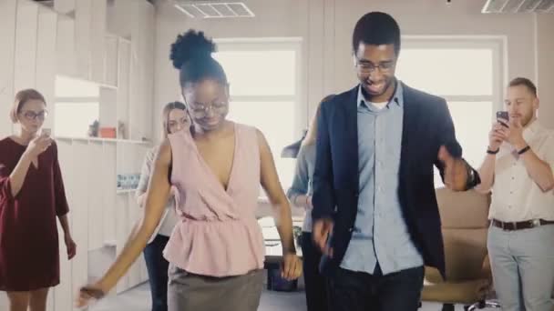 Счастливые афроамериканские друзья танцуют этнический танец на офисной вечеринке. Мультиэтнические бизнесмены делятся весело провести время на работе 4K — стоковое видео