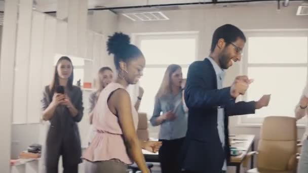 事務所で一緒にダンスの動きをやって 2 人のアフリカ系アメリカ人の友人のパーティーします。多民族のビジネスの人々 が 4 k を仕事で楽しい時を過す — ストック動画