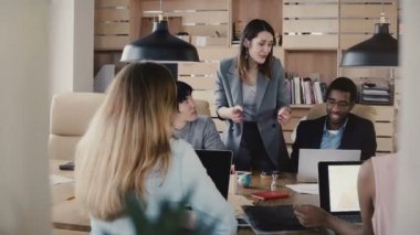 Duygusal beyaz kadın Ceo meslektaşları modern şık ofis alanı 4 k çok ırklı iş takım toplantıda kılavuzları.