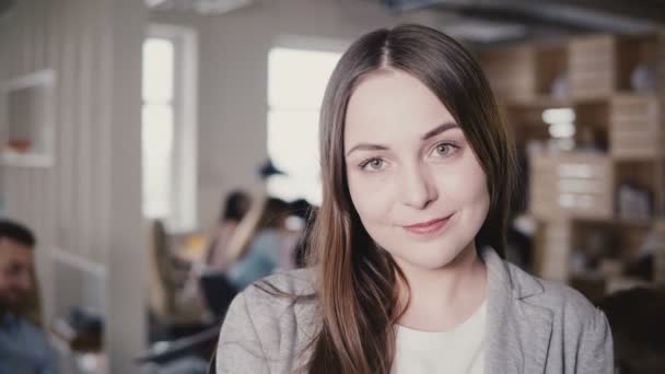 幸せな美しい白人若いマネージャー カメラに笑顔します。近代的なオフィス 4 k でポーズをとる女性の正の上司の肖像画. — ストック動画