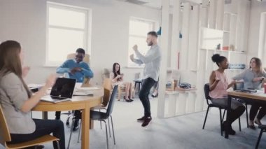 Zafer dansı yapan genç mutlu iş adamı karışık yarış çalışanlar modern ofis 4 k ile takım başarı kutluyor.