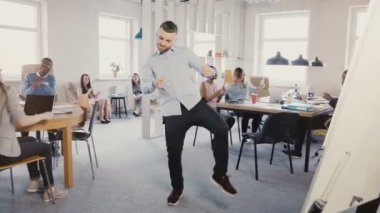 Modern ışık çok etnik gruptan oluşan ofis, alkışlar ve 4 k gülen insanlar zafer dansı yapan genç başarılı iş adamı.